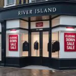 river island store exterior with closing down sale signs and empty window displays showing the retail closure process
